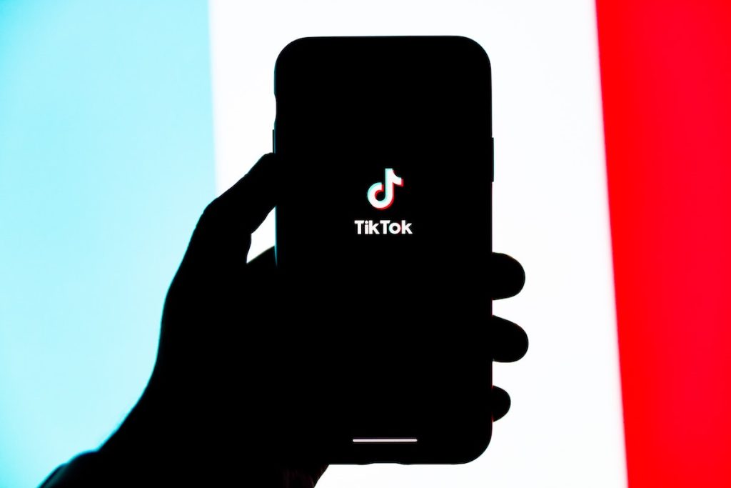 holding phone showing tiktok app